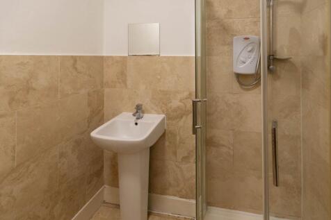 A modern bathroom featuring a cream tiled showe...