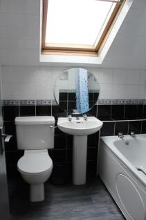 Bright and tidy bathroom featuring a toilet, pe...
