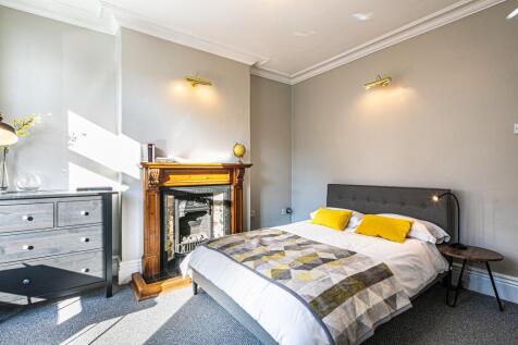 A spacious and well-lit master bedroom featurin...