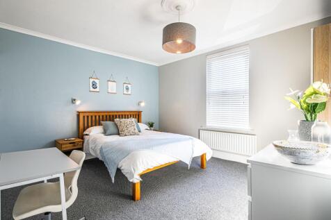 Bright and spacious bedroom featuring a comfort...