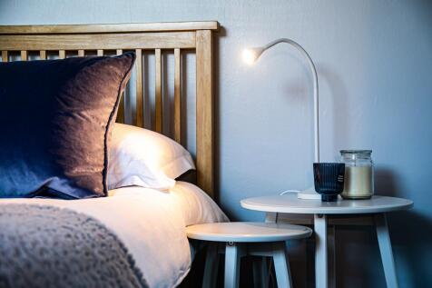 A cozy bedroom featuring a wooden slat headboar...