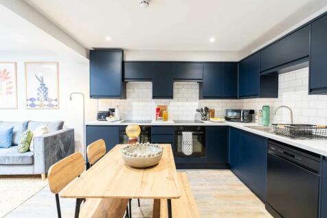 Modern navy blue kitchen with white subway tile...