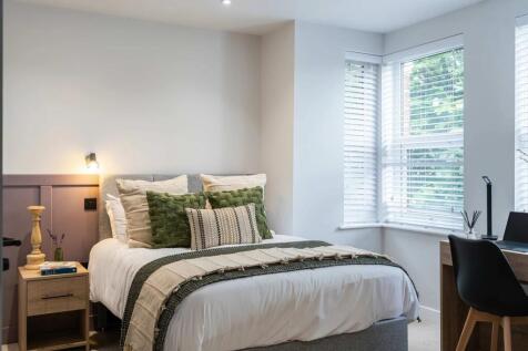 A modern and inviting master bedroom featuring ...