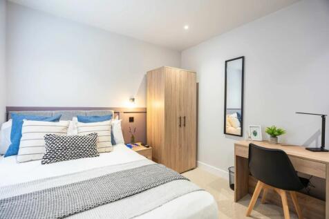 Bright and welcoming double bedroom featuring a...