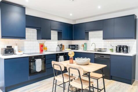 Modern kitchen with sleek navy blue cabinets, a...