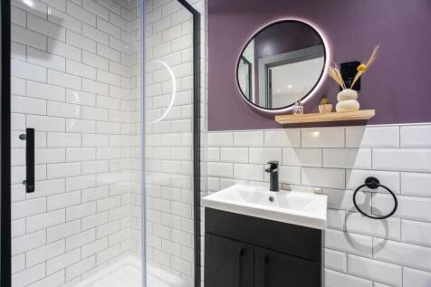 Modern bathroom featuring white subway tiles, a...