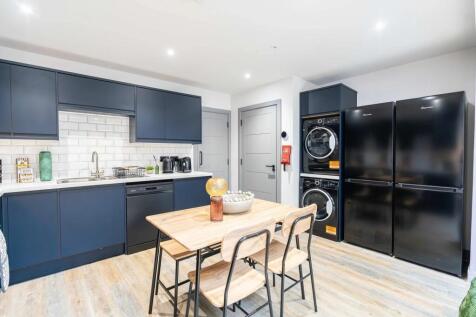 Modern kitchen with sleek navy blue cabinets, w...