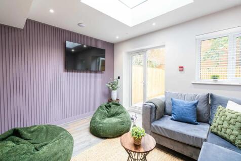 Bright and modern living room featuring a large...