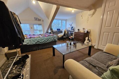 A spacious and cozy living room with large wind...