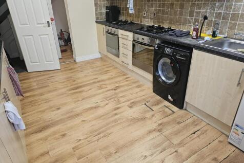 Modern kitchen with wooden flooring, equipped w...