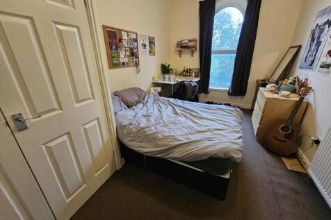 A spacious master bedroom with a comfortable do...