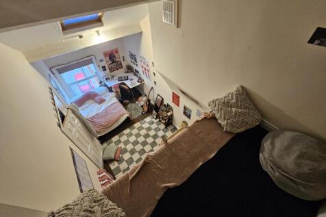 A cozy bedroom featuring a neatly made bed, a w...