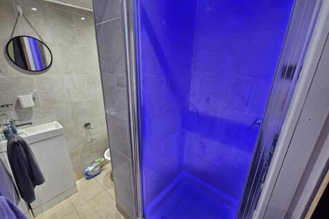 Modern bathroom featuring a spacious shower enc...
