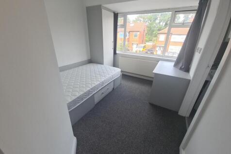 A neat and tidy single bedroom featuring a sing...