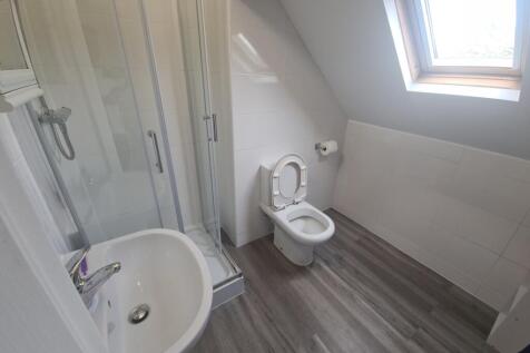 A bright, modern bathroom featuring a walk-in s...