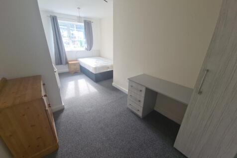 A tidy and well-lit single bedroom featuring a ...