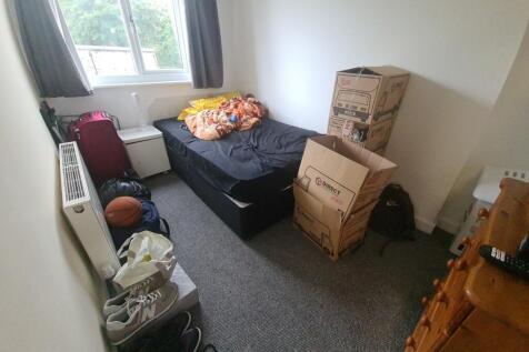 Cozy single bedroom featuring a large window wi...