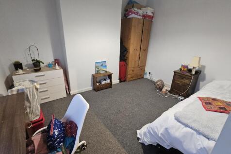 A tidy single bedroom featuring a single bed, d...