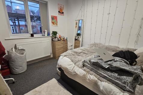 Cozy single bedroom featuring a large window th...