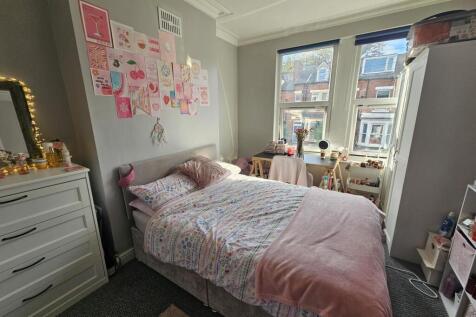 Bright and cozy bedroom featuring a comfortable...