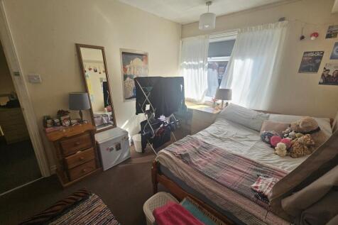 A spacious and well-lit master bedroom with a d...