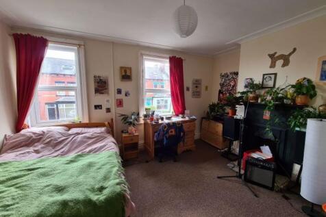 A spacious, cozy bedroom featuring a large doub...