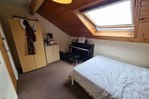 A cozy double bedroom featuring a large skyligh...