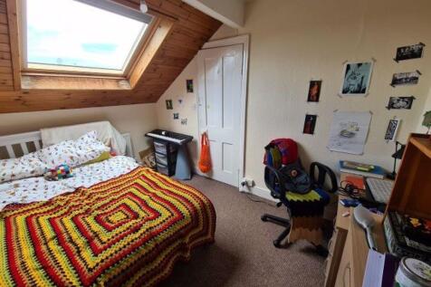 A cozy single bedroom featuring a comfortable b...