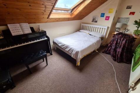 A cozy attic bedroom featuring a comfortable si...