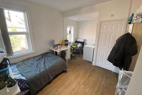 A cozy bedroom featuring a single bed, bright n...