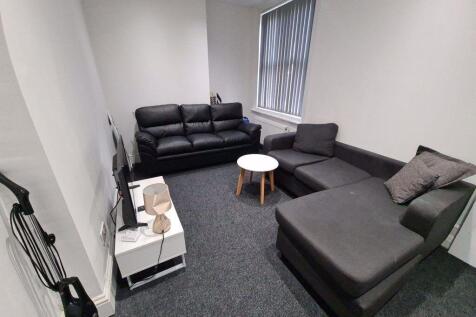 A spacious, well-lit living room featuring a co...