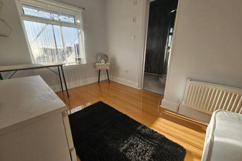 A spacious and well-lit master bedroom with woo...