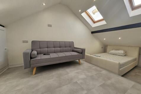 A bright and modern living room featuring a gre...