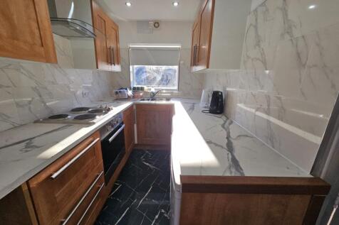 A modern, well-lit kitchen featuring sleek cabi...