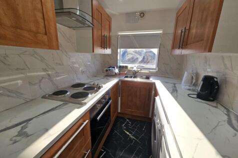 A modern kitchen featuring marble countertops, ...