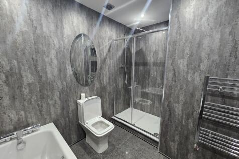Modern bathroom featuring a walk-in shower with...