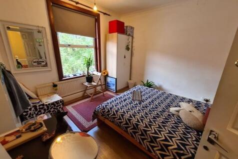 A cozy single bedroom featuring a neatly made b...