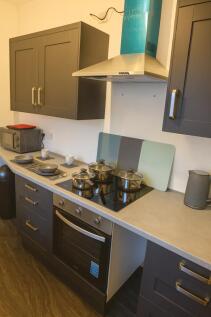 Modern fitted kitchen with dark cabinetry, inte...