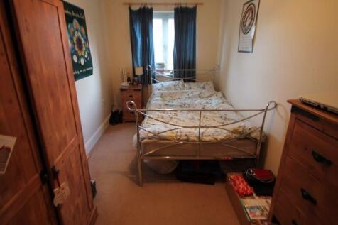 A cozy master bedroom featuring a metal bed fra...