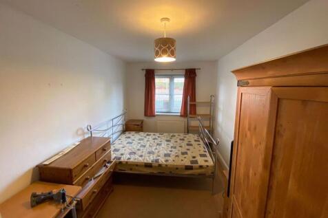 A cozy bedroom featuring a double bed and a woo...