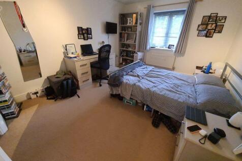 A cozy bedroom featuring a single bed, a window...