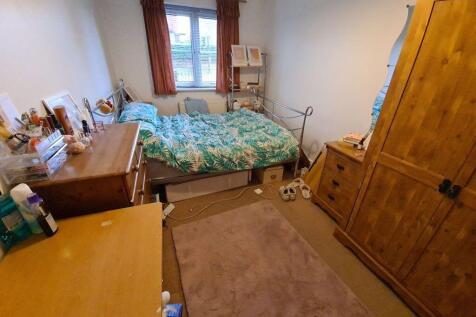 A spacious and cozy bedroom featuring a large b...