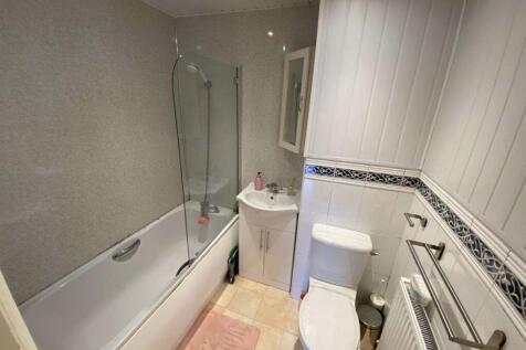 A clean and modern bathroom featuring a bathtub...