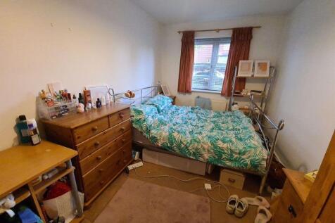 A modest bedroom featuring a double bed with so...
