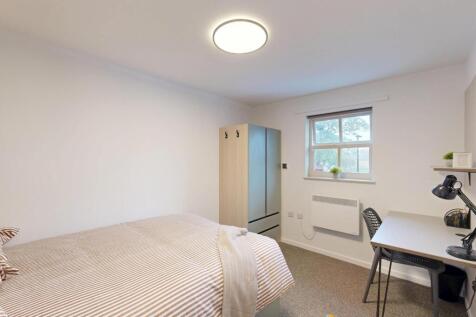 Bright, neatly furnished bedroom with a double ...