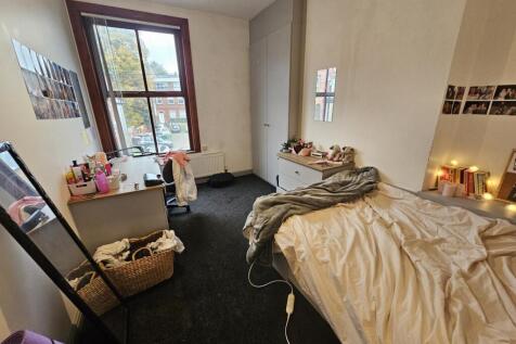 A cozy bedroom featuring a large window that al...