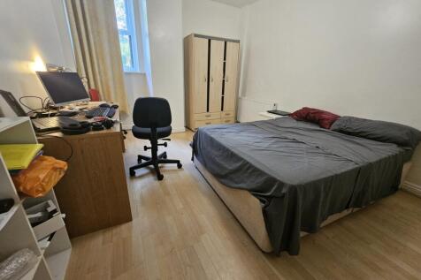 A spacious master bedroom featuring a large bed...