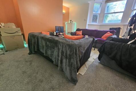 A spacious double bedroom featuring a large bed...