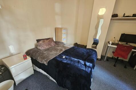 A cozy single bedroom featuring a neatly made b...