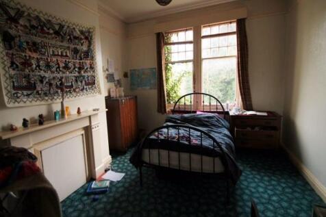 A spacious master bedroom featuring a large win...